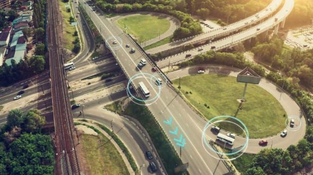 Smart vehicles communicate with each other and infrastructure on a modern highway interchange.